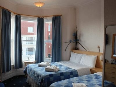 The Brooklyn Hotel family room with blue and white bedding with a bay window